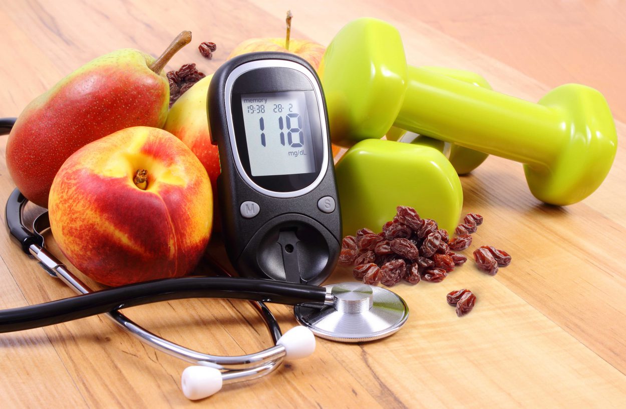 Glucose meter with medical stethoscope, fruits and dumbbells for fitness